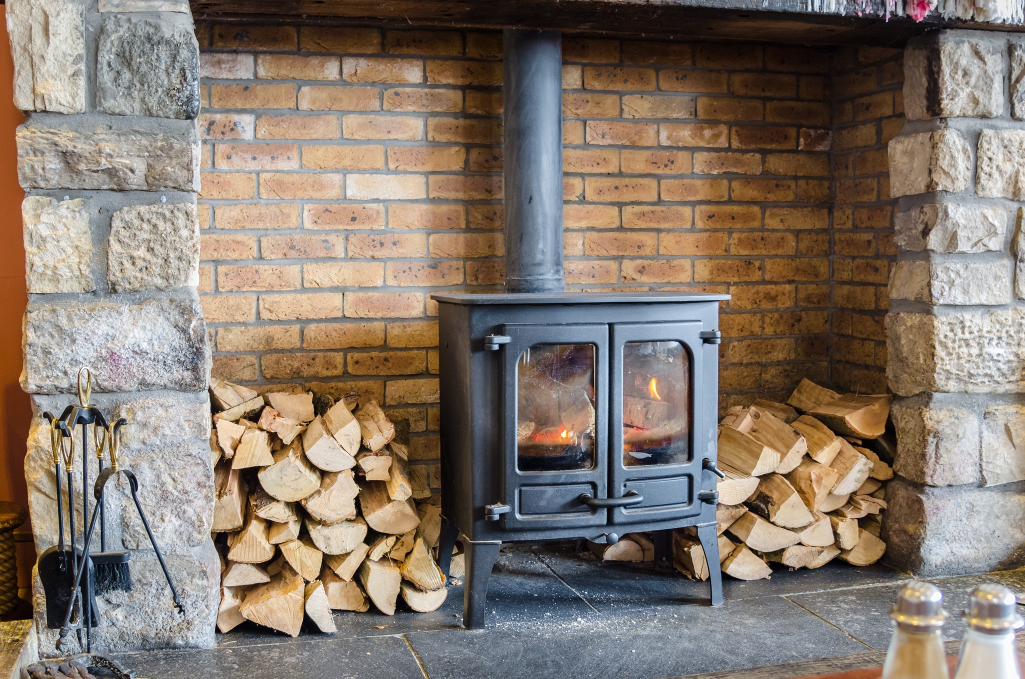 Traditional wood burning stove in brick fireplace