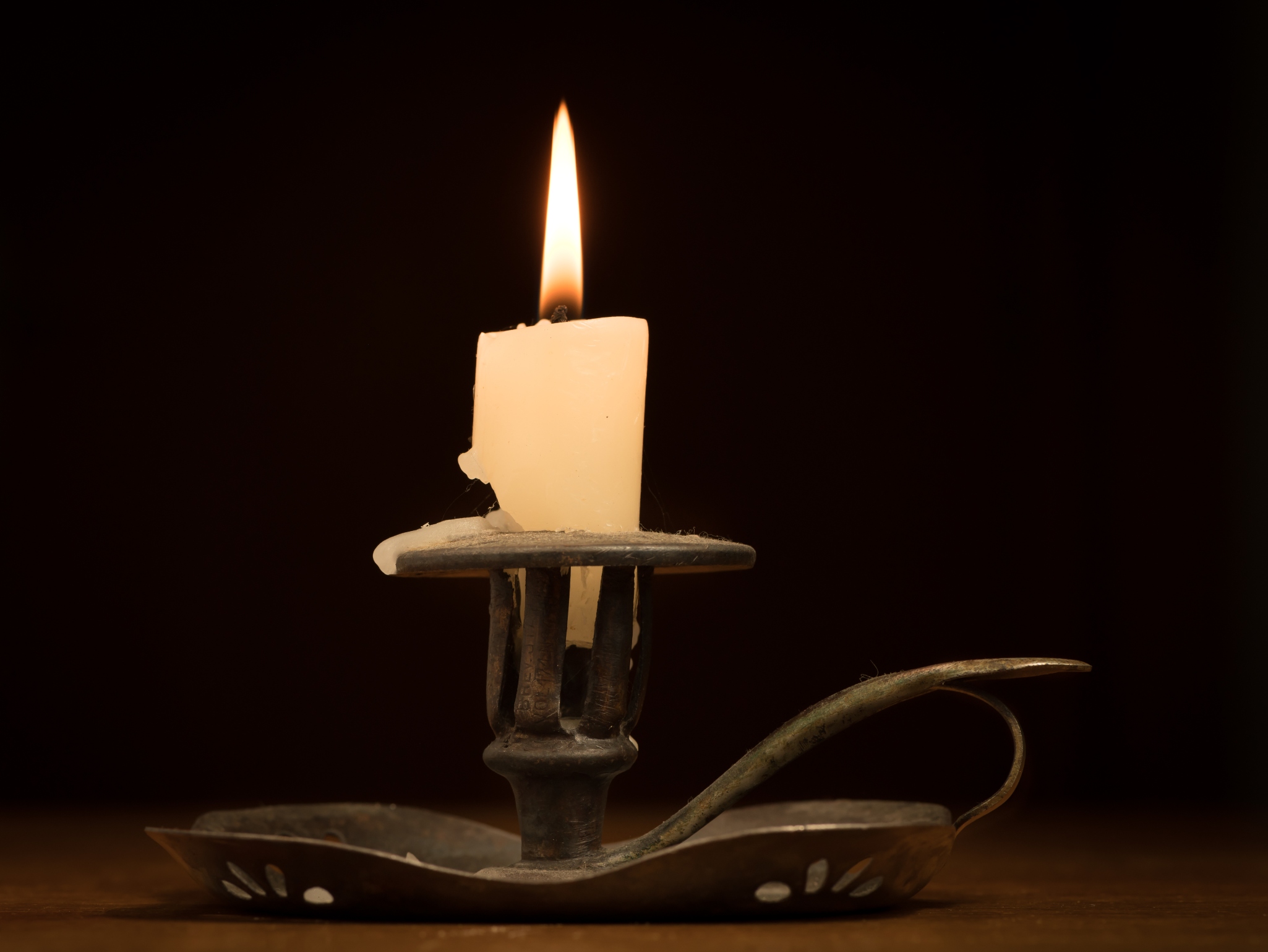 Historic candle holder with melted lit candle